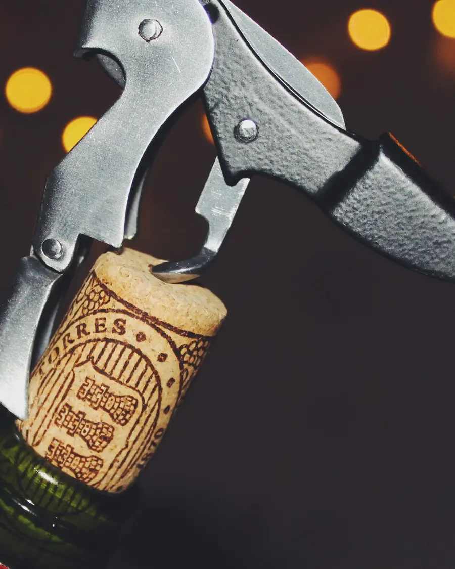 A cork on the screw of a corkscrew, just clear of the bottle neck.